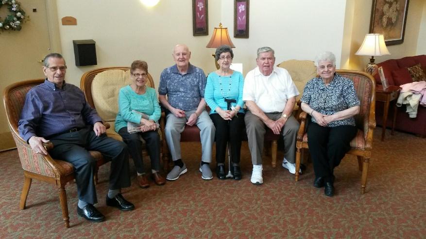 A group of people sitting around a living room
Description generated with very high confidence