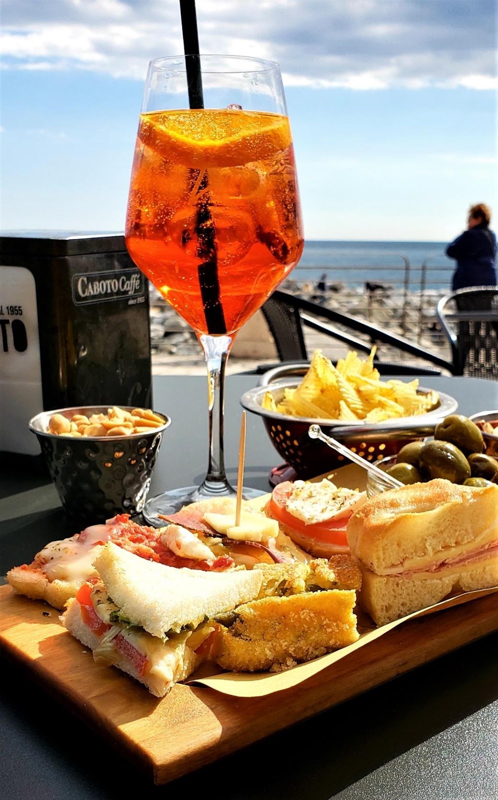 A glass of beer next to a plate of foodDescription automatically generated with low confidence